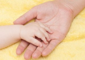 На картинке рука ребенка лежит в руке взрослого, как символ того, что мы воспитываем ребенка в современном обществе.