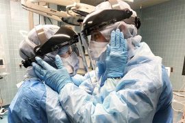 Проблема ответственности перед обществом На картинке два медицинских работника, одетые в защитные костюмы, маски, перчатки, смотрят друг на друга.