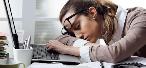 Потеря жизненных сил и энергии. Женщина у компьютера опустила голову на руки от усталости.