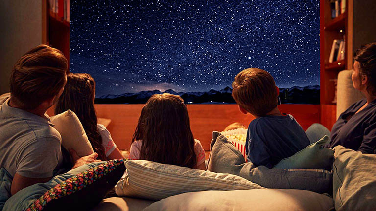 Люди мечтают научиться жить текущим моментом. На картинке семья, наблюдающая за звездами.