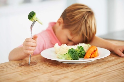 мальчик не хочет кушать овощи, нет аппетита, без настроения он грустит над тарелкой