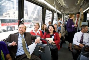 Фото людей в автобусе, весёлые лица, общающихся между собой людей. Люди испытывают радость общения от совместной поездки, от общения друг с другом.