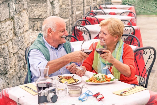 вот они какие, итальянцы - заботятся о пожилых людях, хранят теплые отношения в паре до старости. Пожилая пара пьет вино в ресторане.