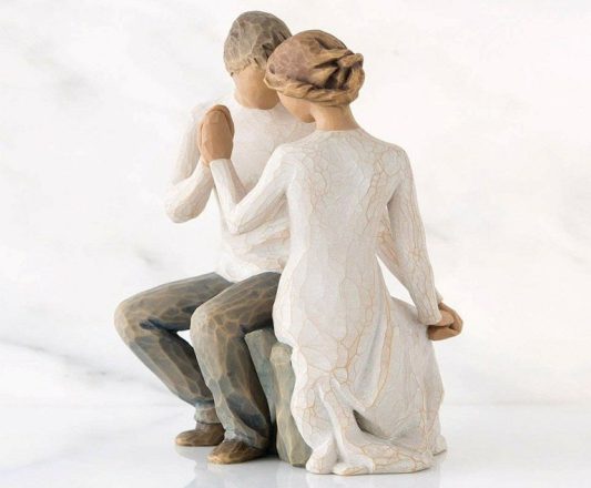 История настоящей любви в фаянсовой статуэтке: мужчина и женщина сидят напротив друг друга, и их ладони соединены в знак настоящей любви.