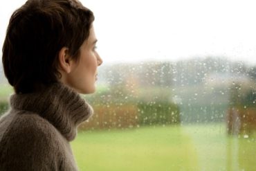 на картинке девушка напряженно смотрит вдаль сквозь завесу дождя, как бы стараясь что-то понять и осознать.